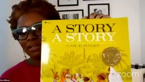 eva wilson holding up a book with a yellow cover titled a story a story