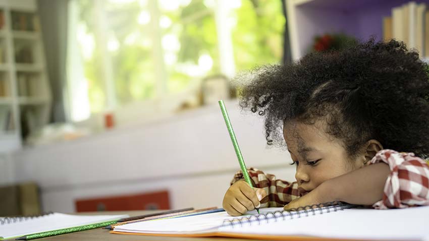 black girl doing homework in a notebook